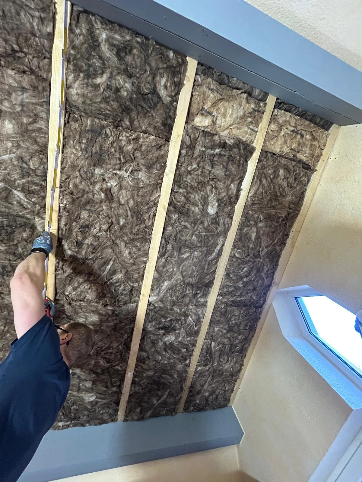 Dämmwolle zwischen Holzlatten in einer Dachschräge