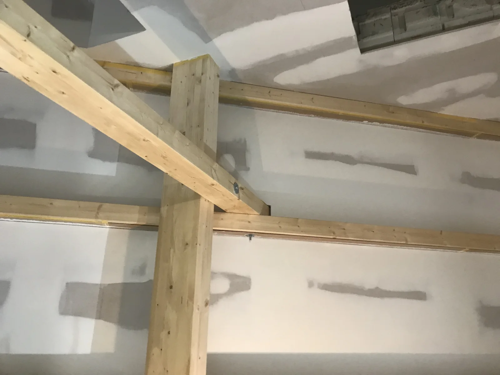 Holzbalken vor Trockenbauwänden im Dachgeschoss